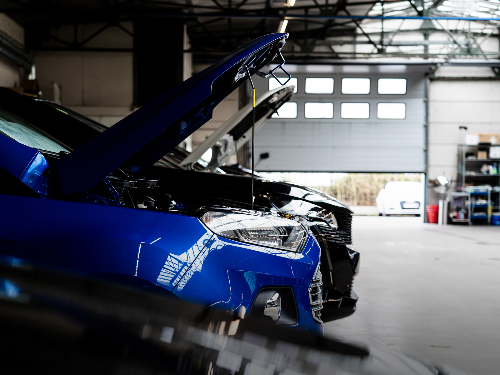 Mechanic servicing a vehicle raised in the workshop
